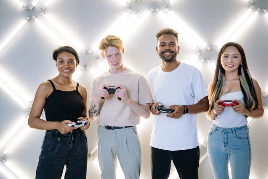 Jugadores jóvenes con mandos Xbox y PlayStation